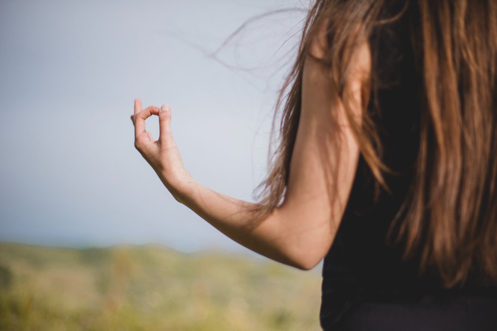 778460 - CAIP | Diario-ABC.Com Back view of a person with long brown hair, outdoors in a field, making a circle with thumb and index finger (hand gesture)