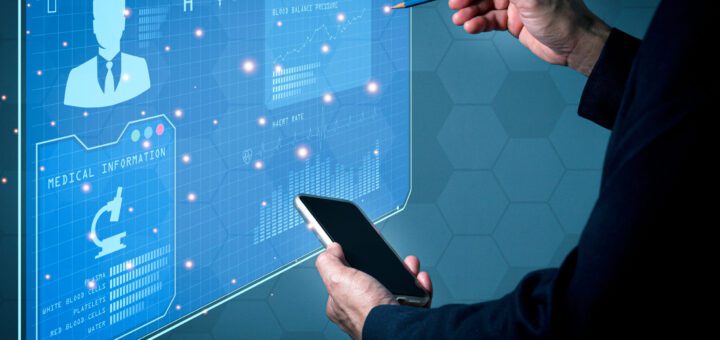 PersonUses a futuristic blue holographic medical dashboard with a phone in hand and a stylus pointing at the display.