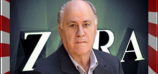 Portrait of a middle-aged man in a dark suit, facing the camera, with large white letters on a dark background behind him.
