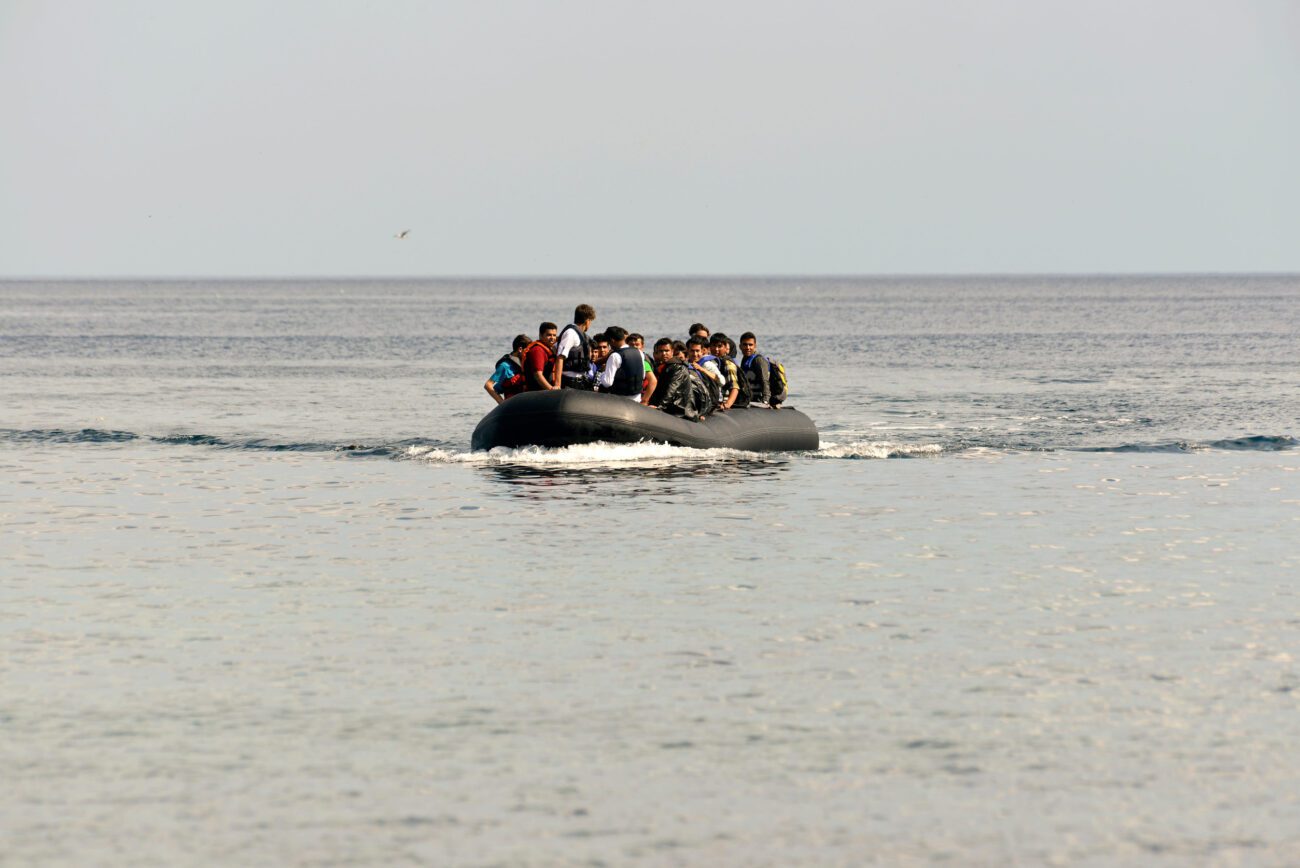 Politica migratoria UE - IP | Diario-ABC.Com Crowded inflatable boat with passengers wearing life jackets on a calm sea near the horizon.