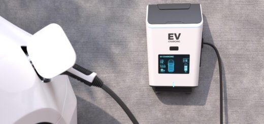 EV charging station connected to a white car, with a blue-lit display on the charger.