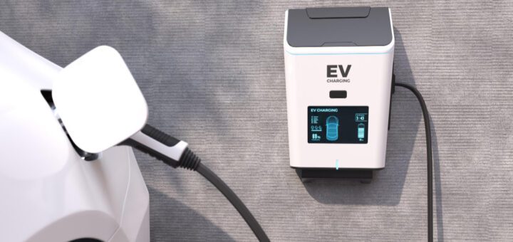 EV charging station connected to a white car, with a blue-lit display on the charger.