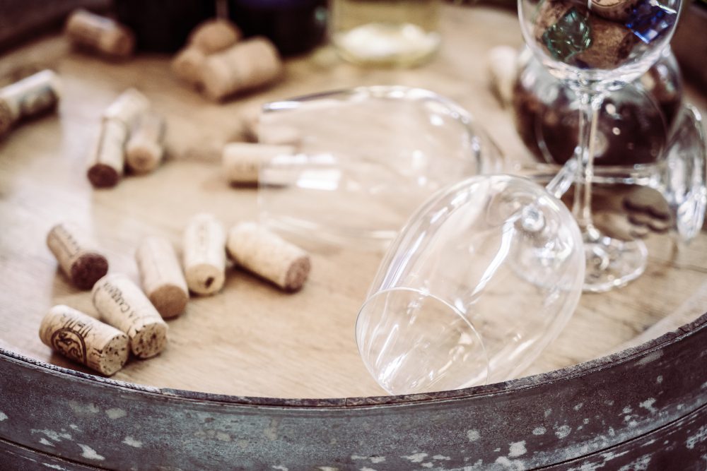 784699 - Curso Cata de Vino | Diario-ABC.Com Wine corks scattered on a wooden table with a glass and decanter in the background